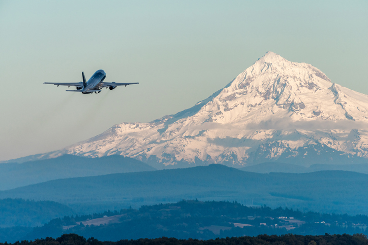 The airplane flying by Mount Hood in Oregon, USA